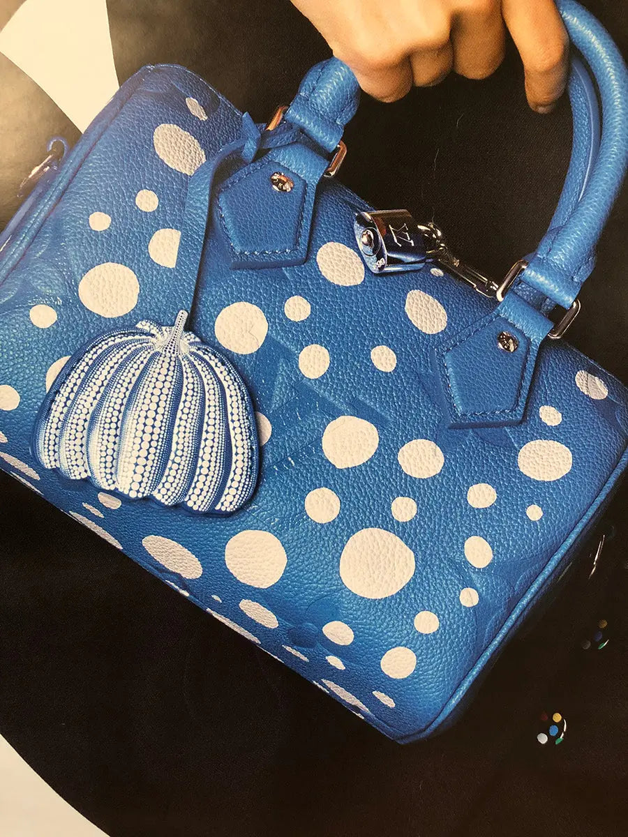Large Yayoi Kusama x Louis Vuitton 2023 exhibition poster featuring vibrant offset lithograph artwork displayed on a wall.
