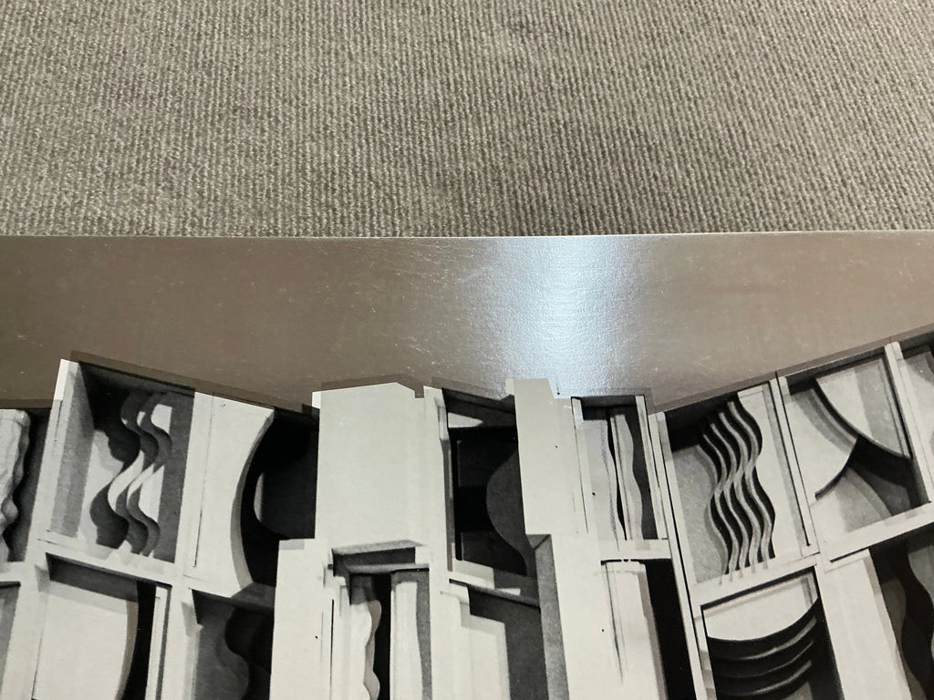 Louise Nevelson Lunar Silence silver foil art print from 1977, showcasing abstract geometric shapes in a modern exhibition display.