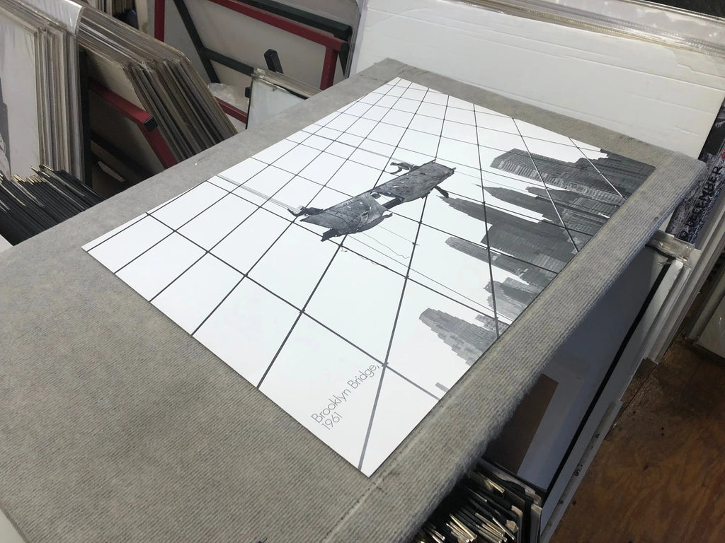 Otto Bettmann 1991 lithograph poster depicting work on the Brooklyn Bridge, featuring detailed illustration of construction scene.