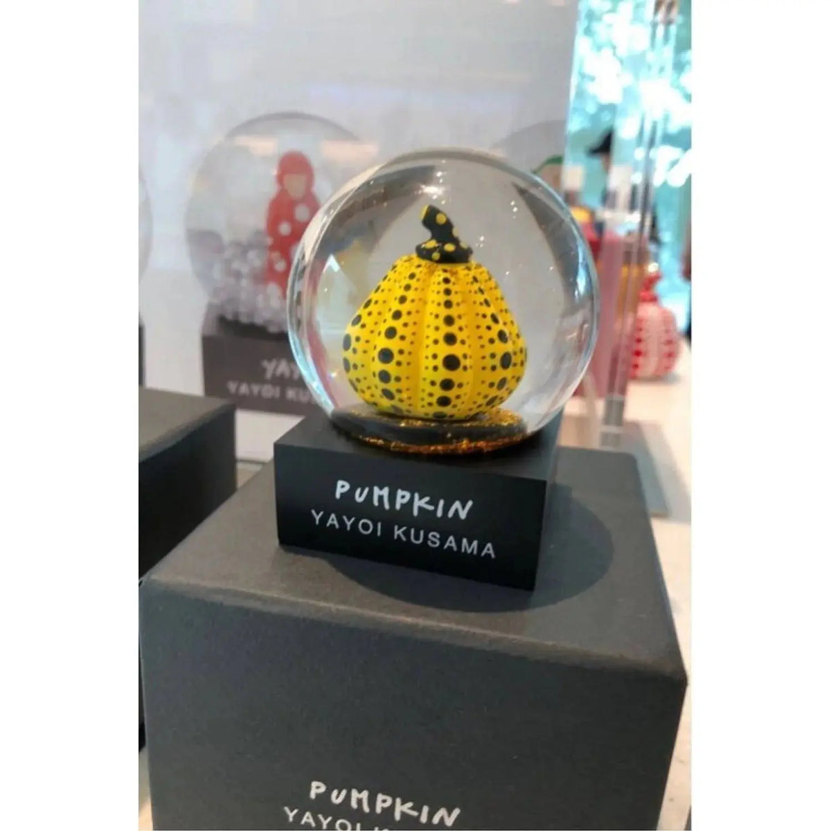 Yayoi Kusama Snow Dome Yellow Pumpkin Limited Edition sculpture featuring a vibrant yellow pumpkin inside a clear glass dome.
